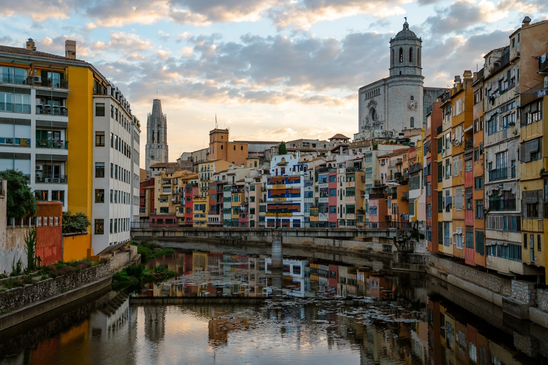 Colorful buildings line a river in a european city.
