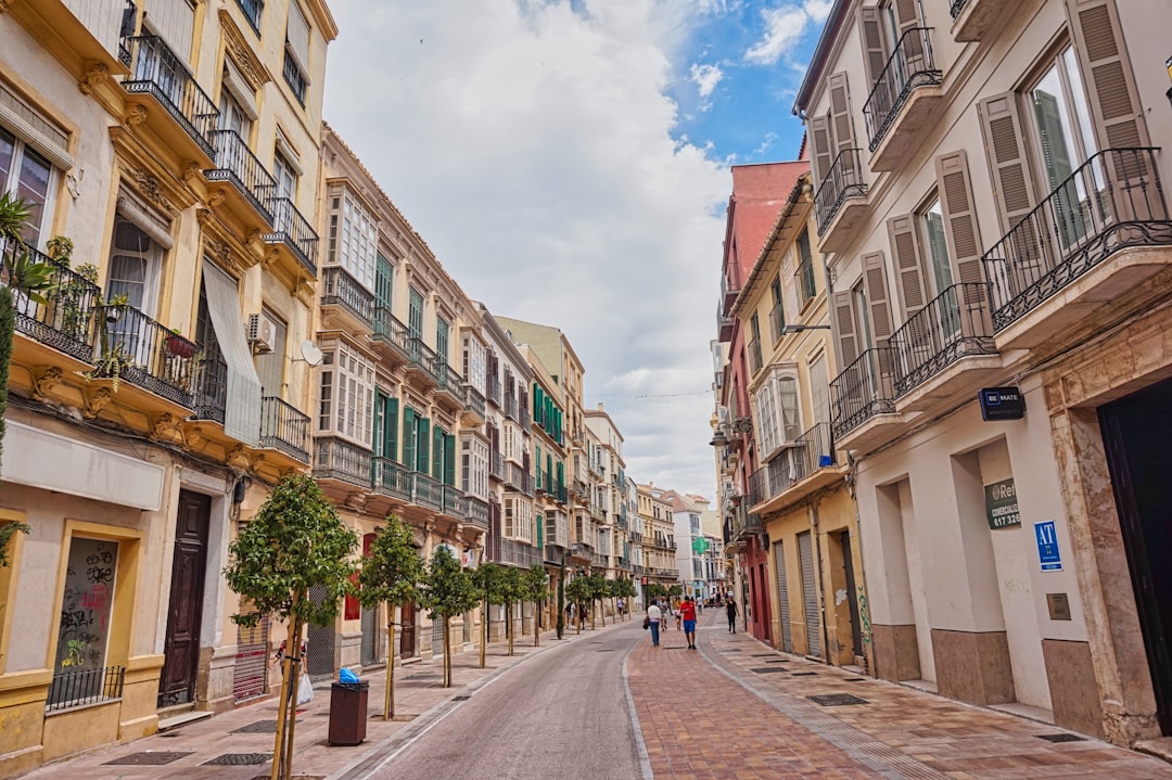 A city street lined with tall buildings with balconies